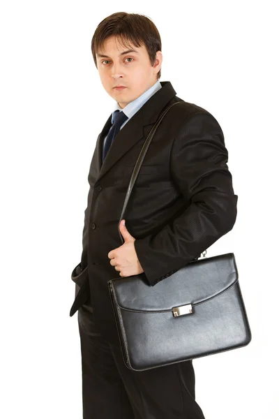 Серьезный молодой бизнесмен держит портфель на плече — стоковое фото