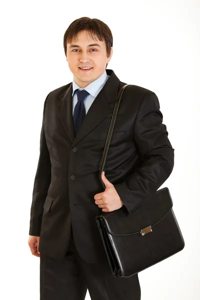 Joven empresario sonriente sosteniendo el maletín en el hombro — Foto de Stock