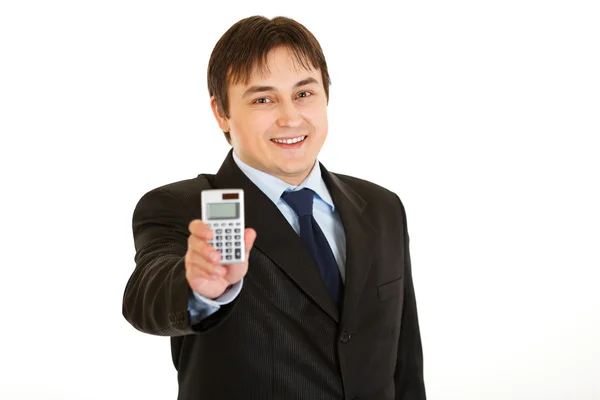 Sonriente joven empresario sosteniendo calculadora en la mano — Foto de Stock