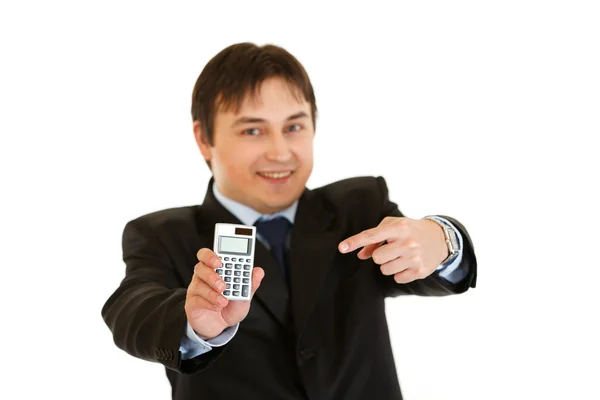 Усміхнений сучасний бізнесмен вказує палець на калькулятор — стокове фото