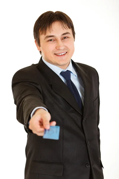 Smiling young businessman giving credit card — Stock Photo, Image