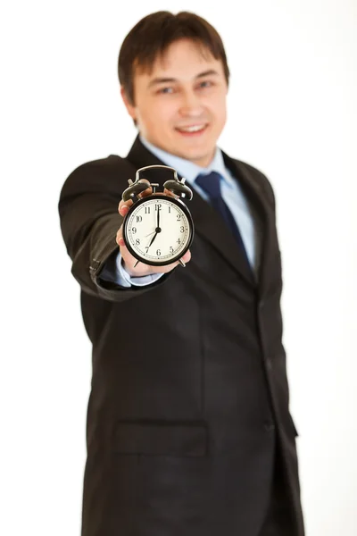 Usměvavý mladý podnikatel v ruce drží budík — Stock fotografie