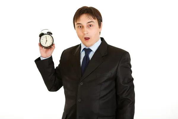 Shocked young businessman holding alarm clock. Lost time concept — Stock Photo, Image
