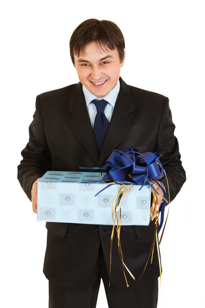 Laughing young businessman holding gift in hands — Stock Photo, Image
