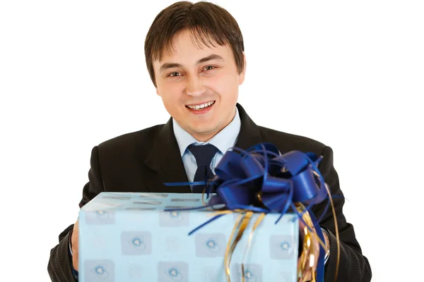 Smiling young businessman holding present in hands — Stock Photo, Image