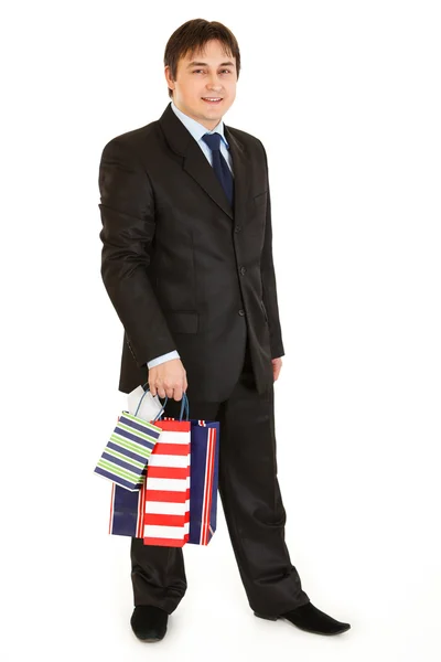 Lachende jonge zakenman houden shopping tassen — Stockfoto