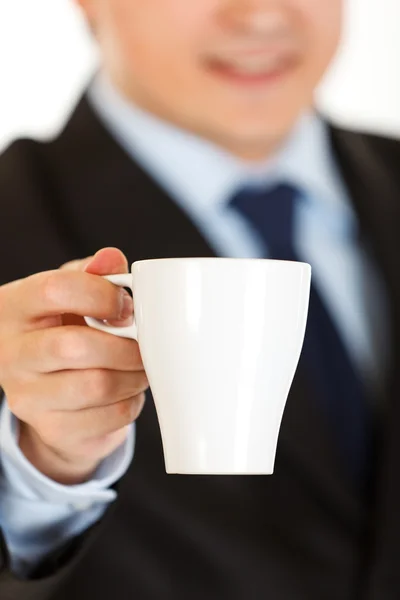 Smiling businessman offering cup of coffee. Close-up. — Stock Photo, Image