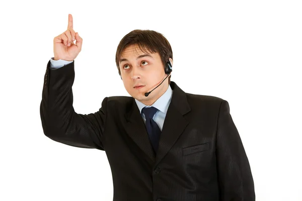 Interesado hombre de negocios moderno con auriculares apuntando dedo hacia arriba — Foto de Stock