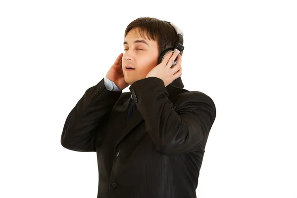 Young businessman in earphone enjoys listening music — Stock Photo, Image