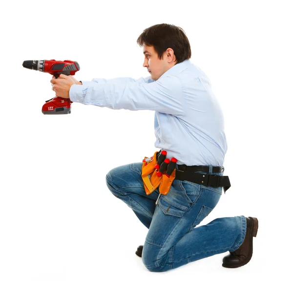Construction worker using electric screwdriver as a gun — Zdjęcie stockowe