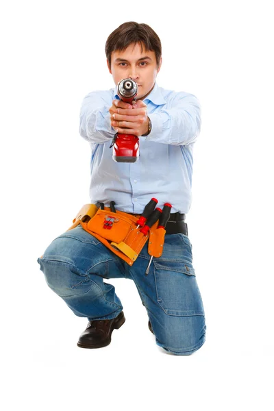 Stavební dělník pomocí polohovacího cvičení jako zbraň ve fotoaparátu — Stock fotografie