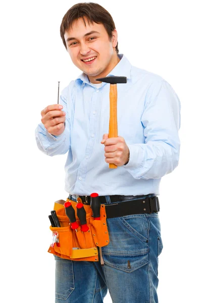 Lächelnde Bauarbeiter spannen Hammer und Nagel — Stockfoto