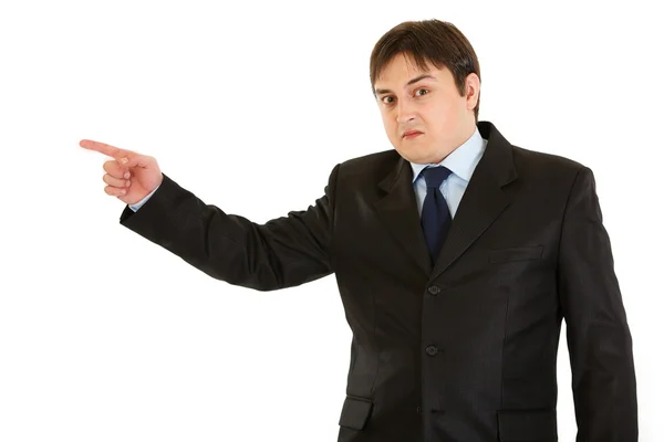 Shocked young businessman pointing finger in corner — Stock Photo, Image