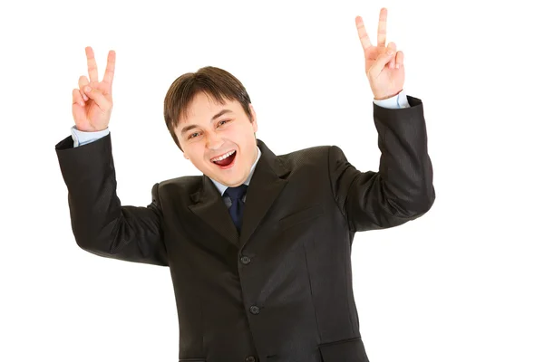 Riéndose joven empresario mostrando gesto de victoria —  Fotos de Stock