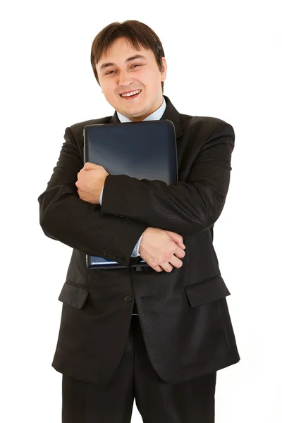 Улыбающийся современный бизнесмен обнимает ноутбук — стоковое фото
