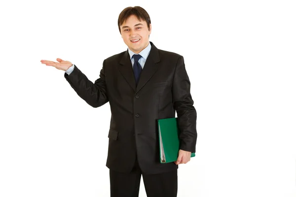 Улыбающийся бизнесмен с папкой, представляющей что-то на пустой руке — стоковое фото