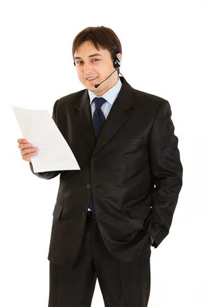 Empresário sorridente com fone de ouvido segurando documento na mão — Fotografia de Stock