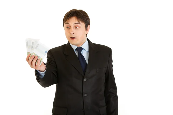 Sorprendido empresario moderno sosteniendo el dinero en su mano — Foto de Stock