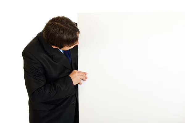 Moderner Geschäftsmann schaut auf leere Plakatwand — Stockfoto