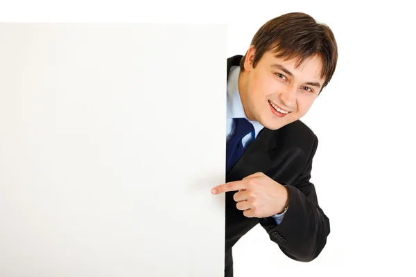 Lächelnder moderner Geschäftsmann zeigt mit dem Finger auf leere Plakatwand — Stockfoto