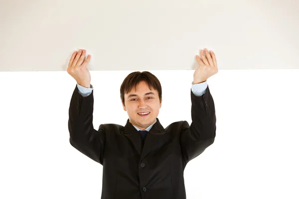 Homme d'affaires moderne souriant tenant le panneau d'affichage vierge au-dessus de la tête — Photo