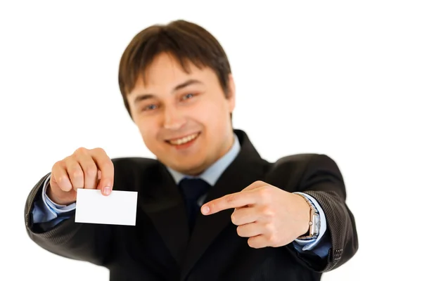 Smiling modern businessman pointing finger at blank business card — Stock Photo, Image