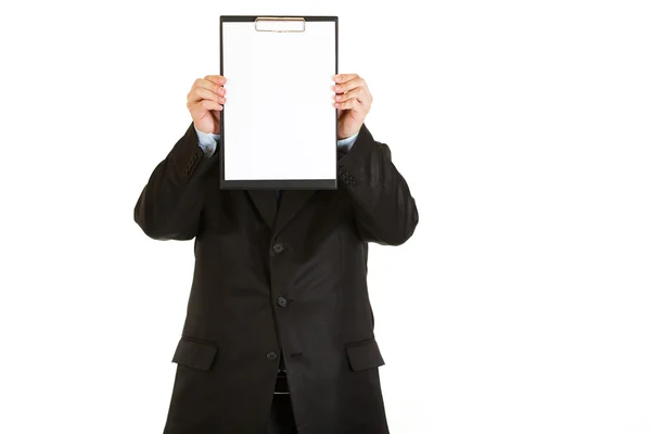 Businessman holding blank clipboard in front of her face — Stock Photo, Image