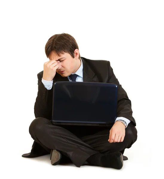 Tired businessman sitting on floor with laptop — Stock Photo, Image