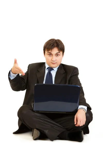 Sentado en el suelo con el ordenador portátil sorprendido empresario señalando en las computadoras portátiles mon —  Fotos de Stock