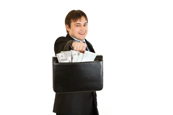 お金のブリーフケースを与える若いビジネスマンの笑みを浮かべてください。 — ストック写真