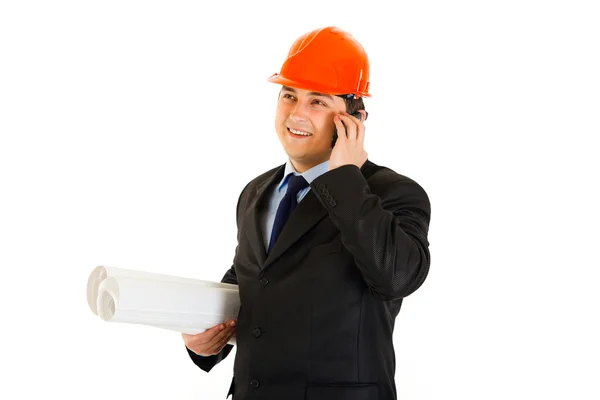 Uomo d'affari sorridente in casco che tiene piani di costruzione e parla sul cellulare — Foto Stock