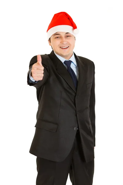 Happy young businessman in Christmas hat showing thumb up gesture — Stock Photo, Image