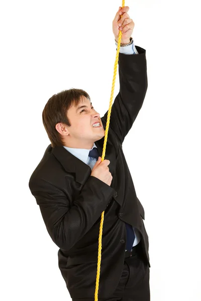 Упрямый бизнесмен взбирается по веревке — стоковое фото