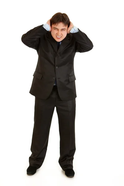Раздраженный бизнесмен закрывает уши руками — стоковое фото