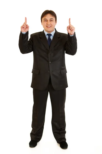 Lachende jonge zakenman die omhoog wijst — Stockfoto