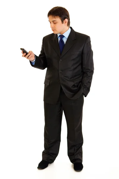 Портрет бизнесмена в полный рост, держащего в руке мобильный телефон и смотрящего на i — стоковое фото