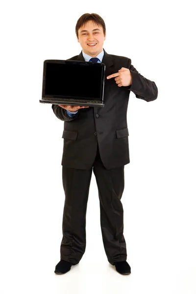 Полный портрет улыбающегося современного бизнесмена, указывающего пальцем на лапто — стоковое фото