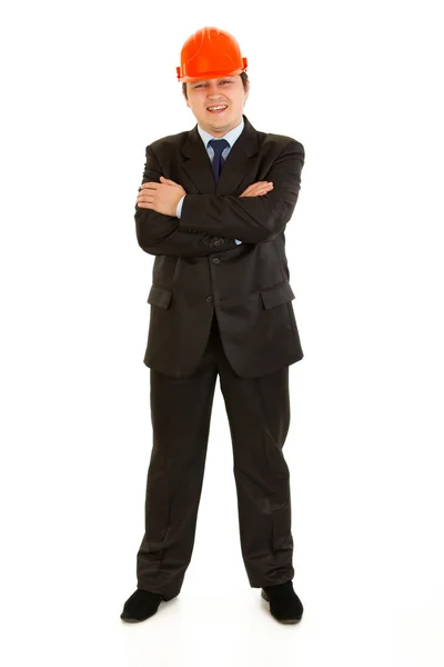 Uomo d'affari sorridente in casco con le braccia incrociate sul petto — Foto Stock