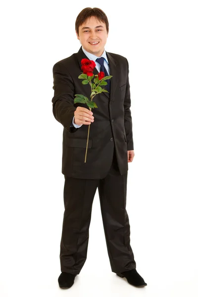 Retrato de comprimento total de homem de negócios moderno sorridente com rosa vermelha na mão — Fotografia de Stock