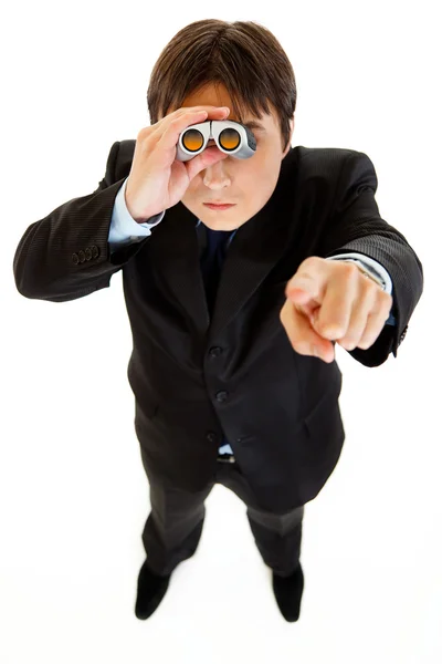 Hombre de negocios serio mirando a través de los prismáticos y señalándote con el dedo — Foto de Stock