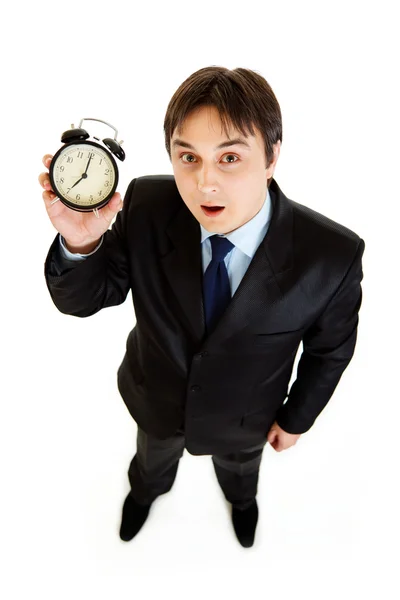 Surprised young businessman holding alarm clock in hand — Stock Photo, Image