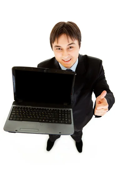 Usmívající se moderní podnikatel drží notebooky prázdná obrazovka a ukazuje palec — Stock fotografie