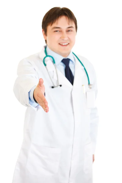 Smiling medical doctor stretches out hand for handshake — Stock Photo, Image