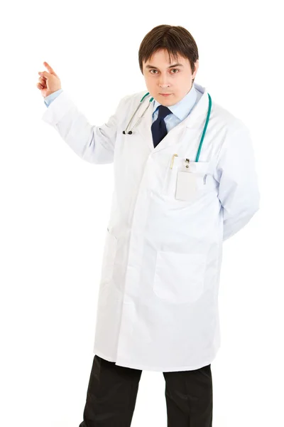 Seriöser Arzt zeigt mit dem Finger in die Ecke — Stockfoto