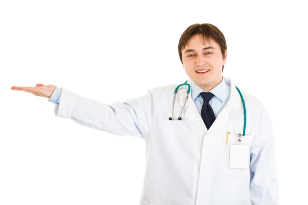 Bir şey üzerinde boş el sunulması gülümseyen tıp doktoru — Stok fotoğraf