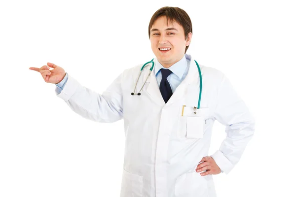 Médico sonriente señalando con el dedo algo — Foto de Stock