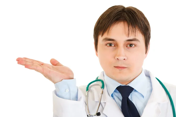 Serious doctor presenting something on empty hand — Stock Photo, Image
