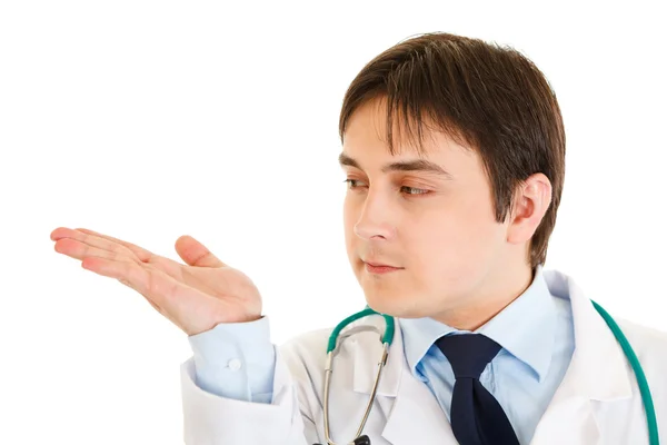 Ernsthafter Arzt präsentiert etwas mit leeren Händen — Stockfoto