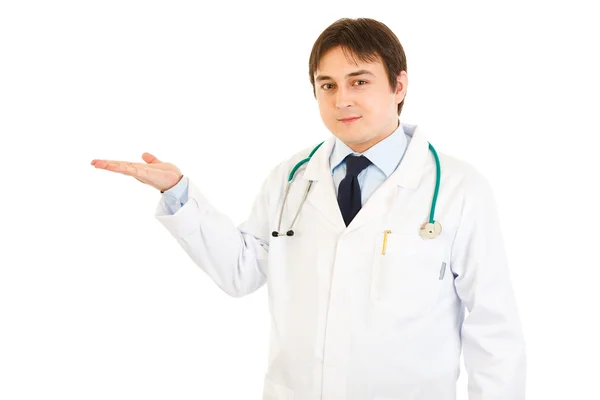 Smiling medical doctor presenting something on empty hand — Stock Photo, Image