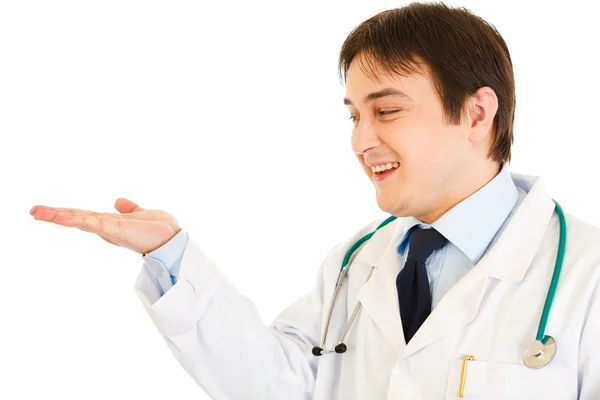 Smiling medical doctor presenting something on empty hand — Stock Photo, Image